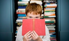 Boy peering over top of book