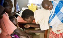 Betty Acao, a newly trained community vaccinator, helps conducts an immunisation programme.