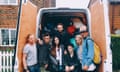 The team of young people pose in front of a van