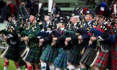 A group of pipers marching at the Highland Games in Braemar, wearing a variety of tartans.