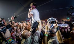 Foals singer and guitarist Yannis Philippakis is held aloft by security as he jumps off the stage during the 23rd Sziget in Hungary