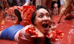 A woman lays on a puddle of tomato juice during the 2103 tomatina tomato fight.