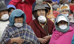Residents wearing masks to protect their airways from volcanic ash listen to President Correa
