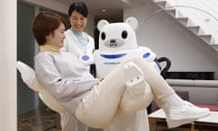 A Robear nursing robot carries a patient during a test exercise in Japan