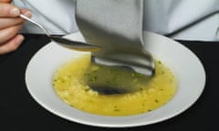 A man eating lunch with his tie in his soup