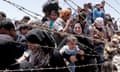 A picture taken from the Turkish side of the border between Turkey and Syria shows Syrian refugees waiting on the Syrian side of the border crossing near Akcakale, Sanliurfa province, south-eastern Turkey