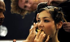A model eats an apple backstage at fashion week
