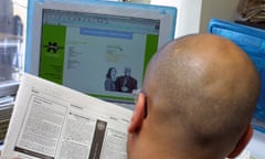 A jobseeker looking at an internet jobs website and a newspaper