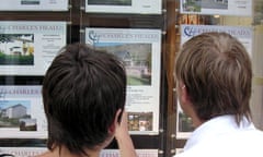 A young couple look in an estate agent's window