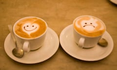 Face designs on cups of cappuccino coffee