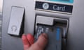 A woman uses a barclays bank ATM