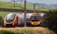 A Virgin train passes a First Group train on the west coast line