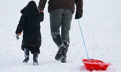 A man and child pull a sledge in the Chiltern Hills