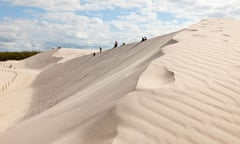 Tourists walking in the dunes at Slowinski national park on the Baltic coast.