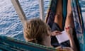 Woman lays in hammock writing