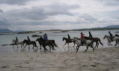 Horses run along the beach in Connemara