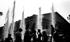 People silhouetted against fountains in central Moscow