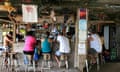 People sitting on stools at Shipwreck beach bar, St Kitts island