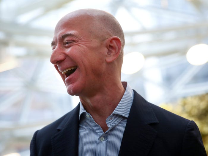 FILE PHOTO: Amazon founder and CEO Jeff Bezos laughs as he talks to the media while touring the new Amazon Spheres during the grand opening at Amazon's Seattle headquarters in Seattle, Washington, U.S., January 29, 2018.   REUTERS/Lindsey Wasson/File Photo