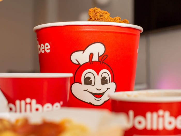 Jollibee branded containers with fried chicken sticking out of the top, larger container.