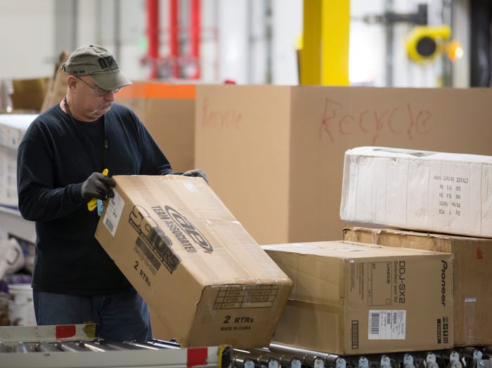 An Amazon worker sorts through incoming merchandise at the Amazon fulfillment center on February 13, 2015 in DuPont, Washington.