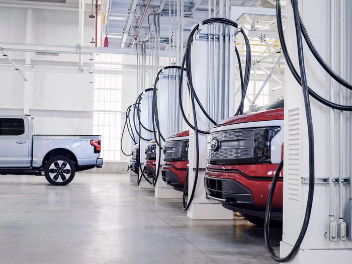 Ford F-150 Lightning cars lined up at charging points.