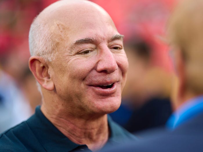 Jeff Bezos smiles as he talks to a man