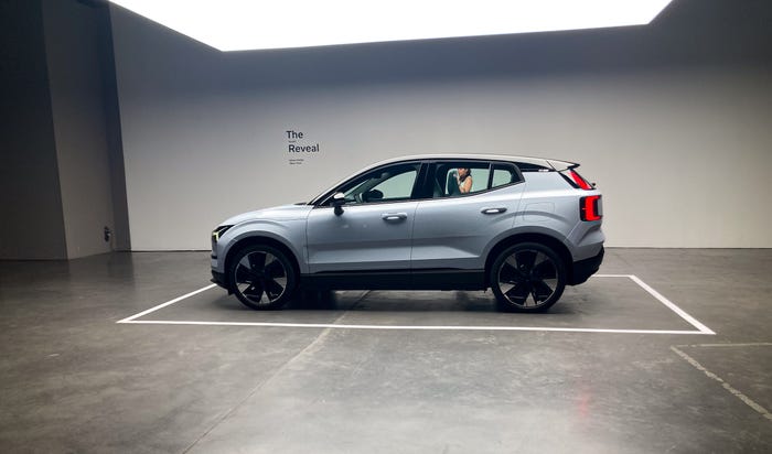 A silver-colored Volvo EX30, which has been parked in an exhibition space marked with a white line.