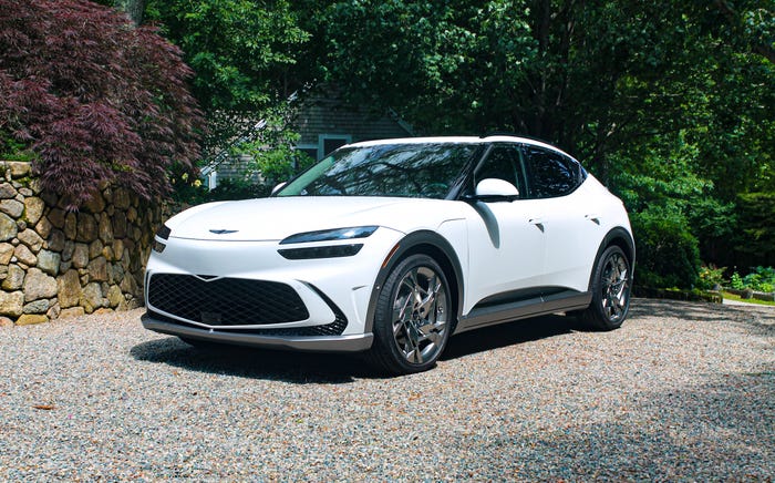 The Genesis GV60 electric SUV, with green trees in the background.