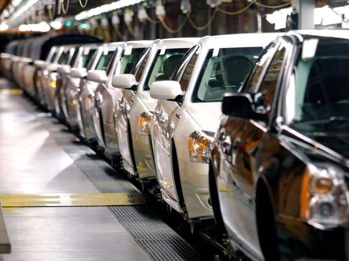 Cars lined up in assembly line.