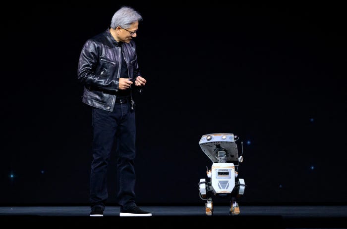 Jensen Huang smiling and looking at a robot