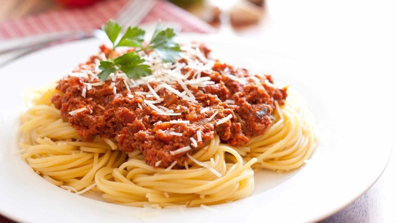 plate of spaghetti with tomatoes and parmesan cheese