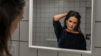 Demi Moore looking at the mirror in a scene from The Substance film.