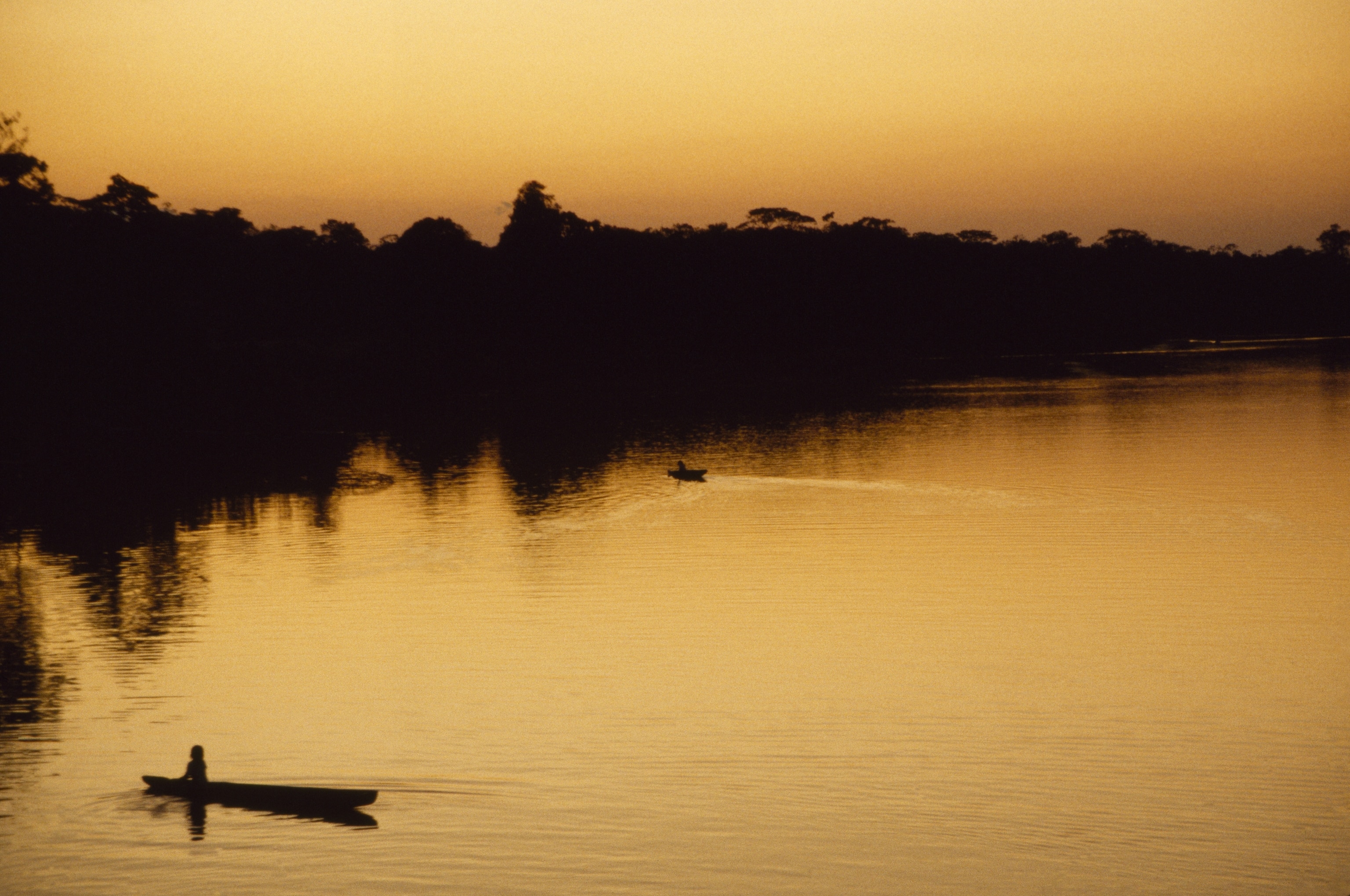 People in canoes on the calm waters of the Amazon River