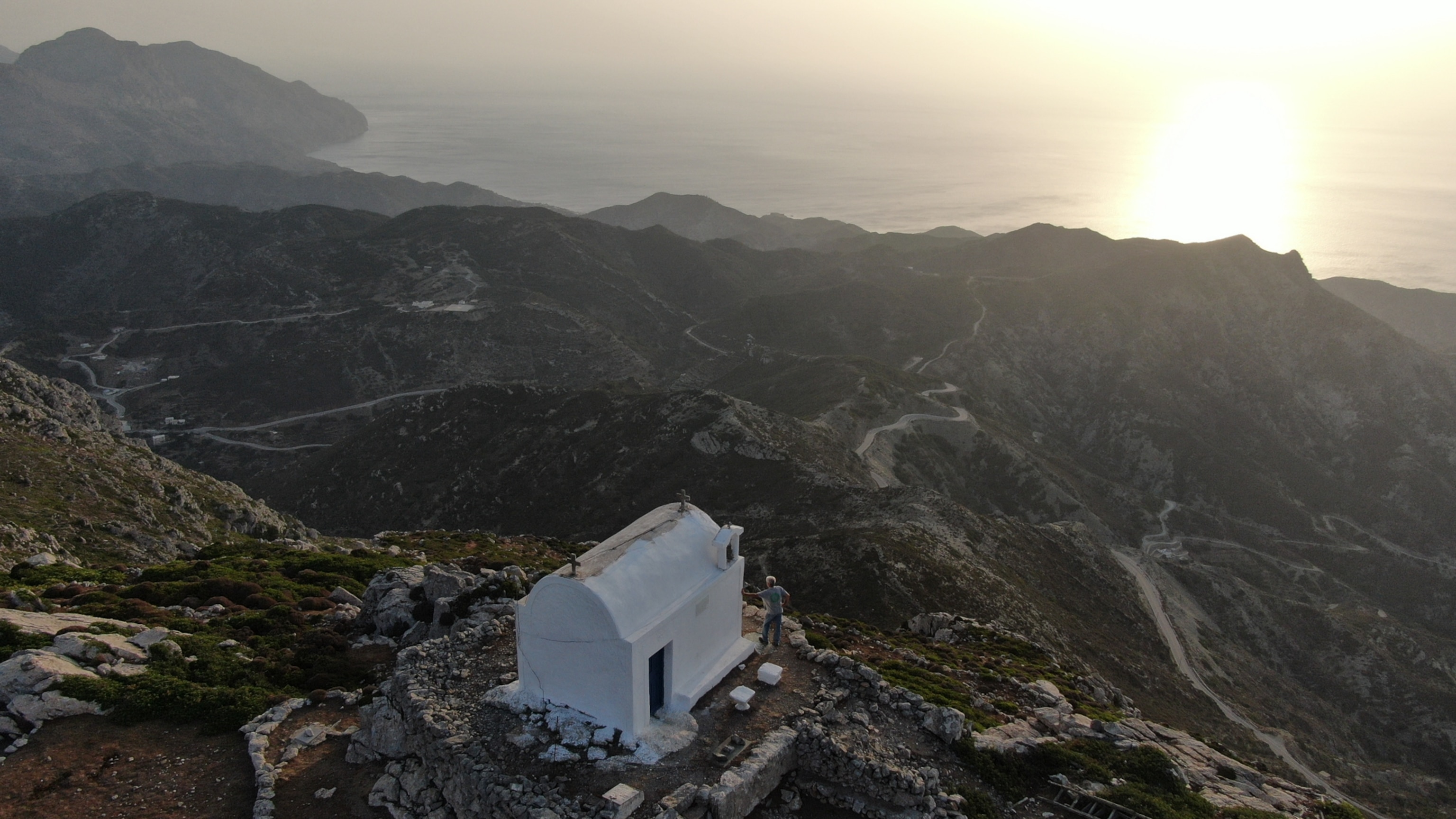 A man visits and leans on the Profitis Ilias chapel overlooking the sea