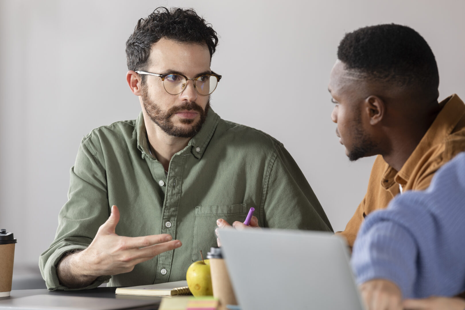 Young man discussing with his colleague during study session.