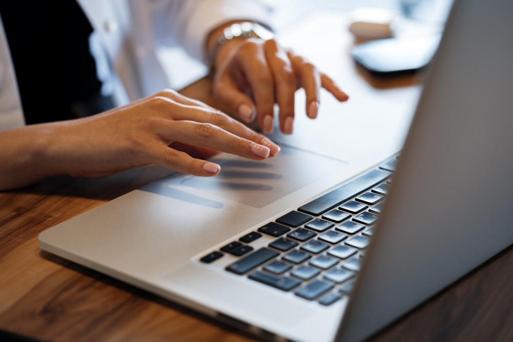 close-up-woman-hands-typing-laptop-cafe