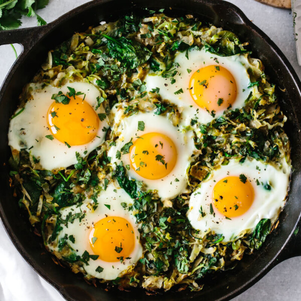 Green shakshuka in a cast iron pan.