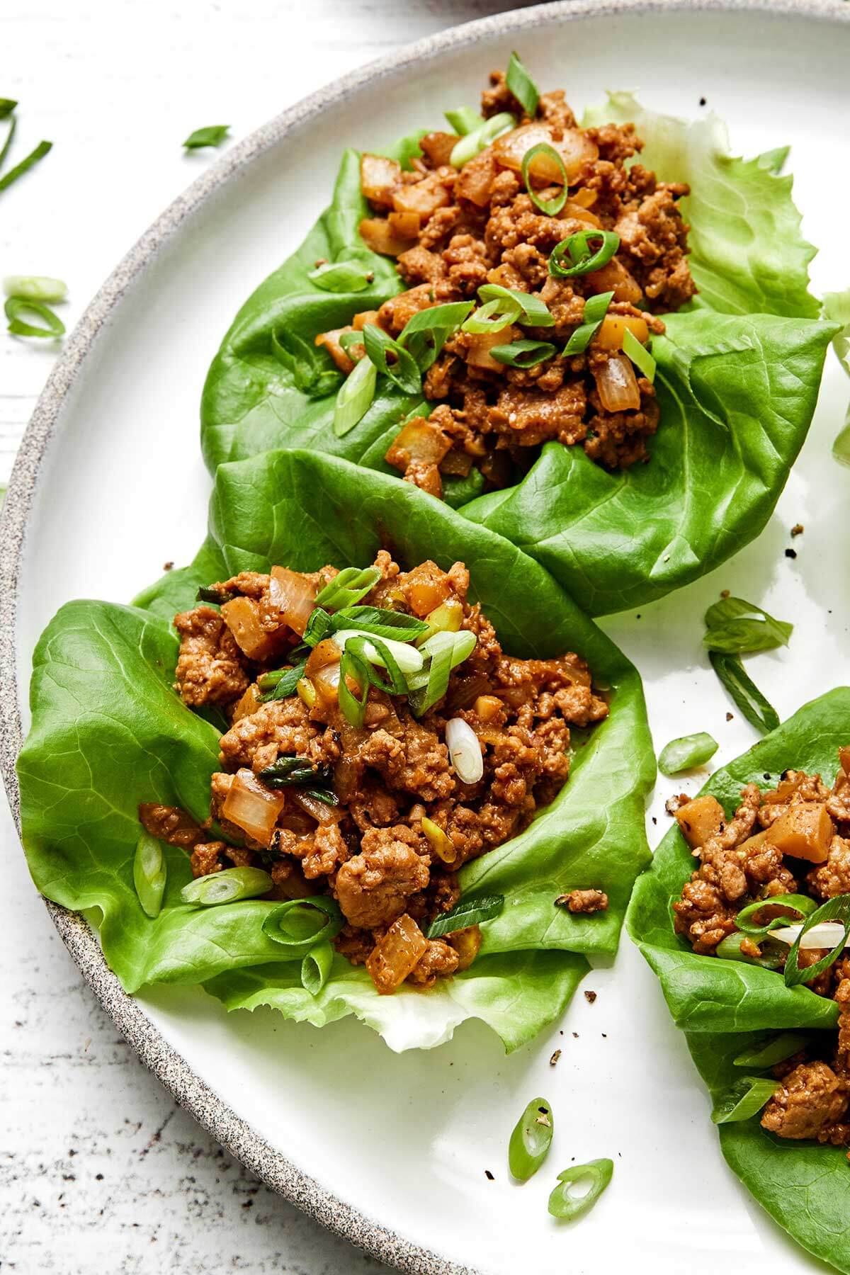 Chicken lettuce wraps on a white plate.