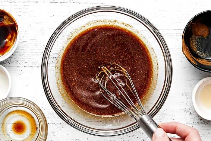 Whisking a chicken sauce in a bowl.