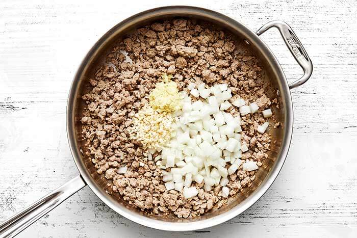 Cooking ground chicken with onion in a pan.