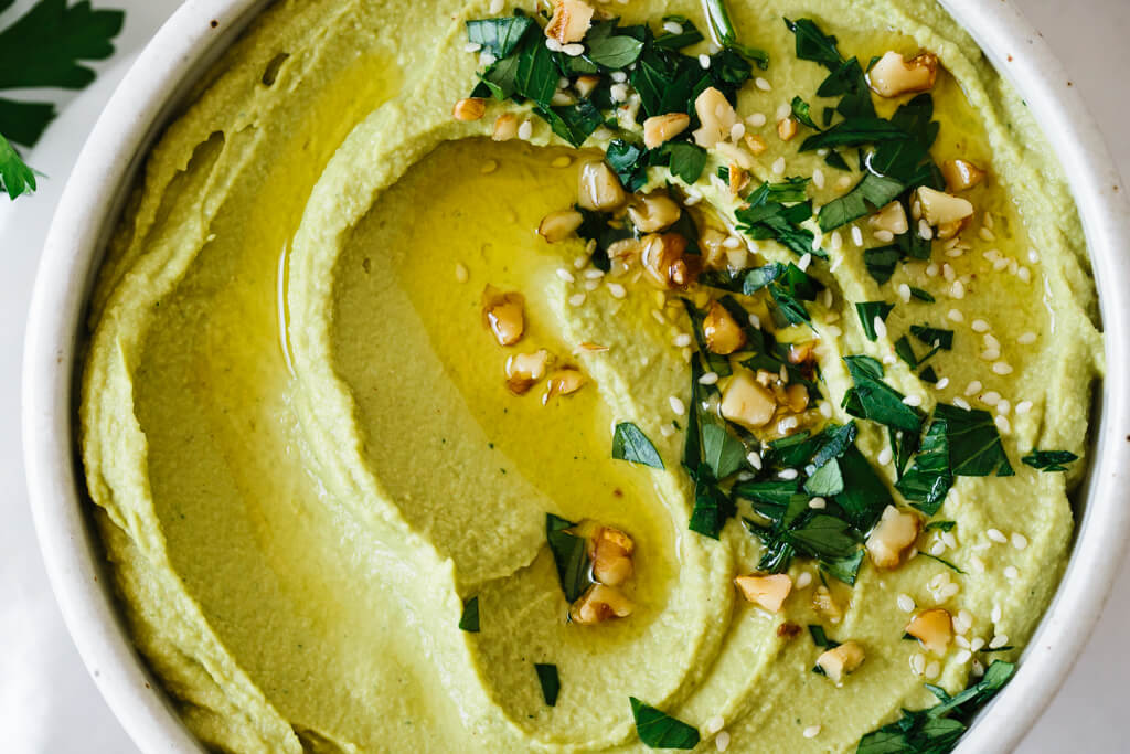 Up close photo of green hummus.