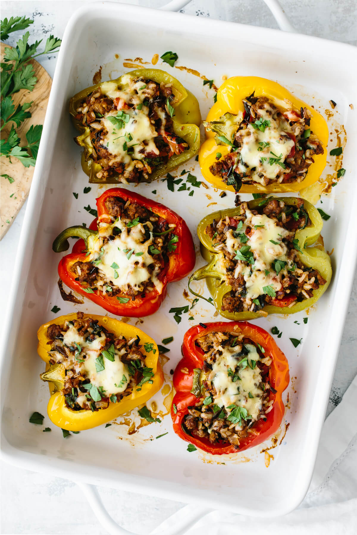 Six stuffed peppers in a casserole dish.