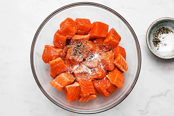 Salmon cubes mixed with salt and pepper