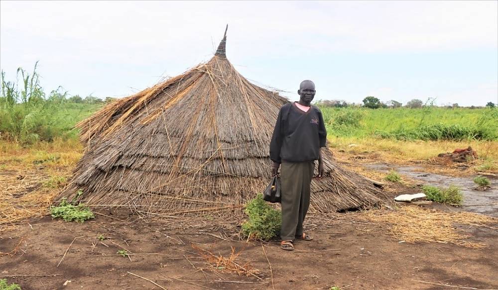 A South Sudanese man in front of his house destroyed by flooding in Kangu/ Kujonok 