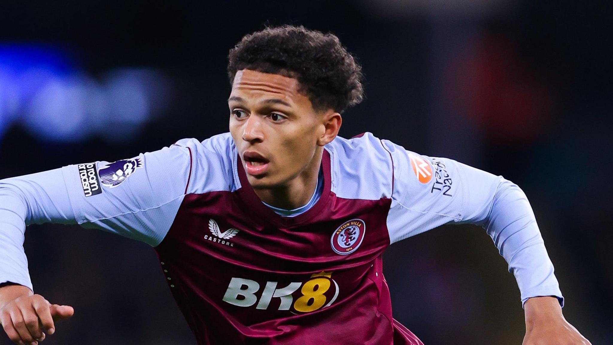 Omari Kellyman spreads his arms and runs while wearing Aston Villa's claret and blue home kit