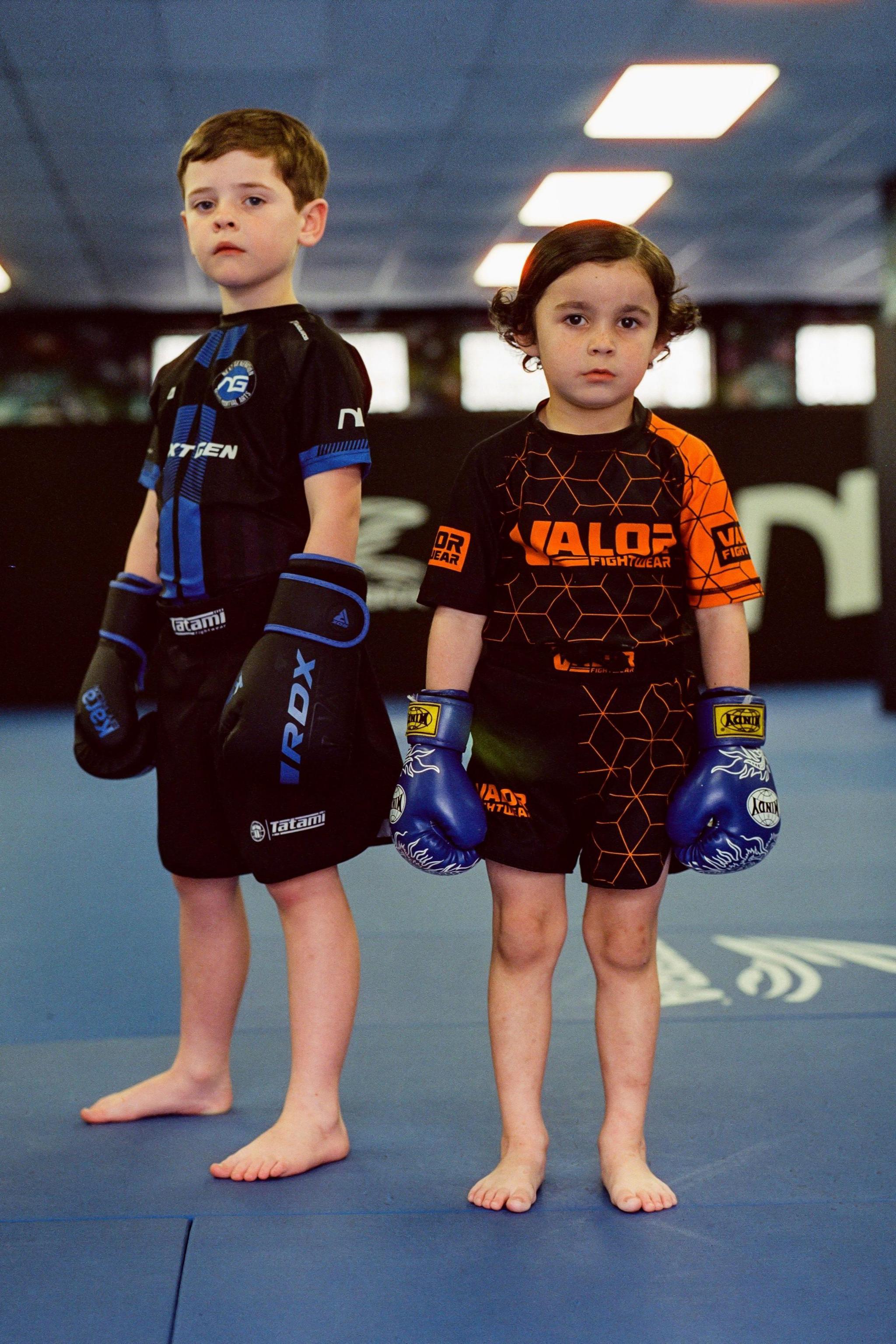 Two young gym-goers pose for a photo wearing gloves