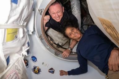 American astronauts Barry Wilmore and Sunita Williams posing for a portrait inside the vestibule between the forward port on the International Space Station