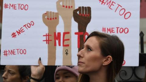 protesters hold metoo signs