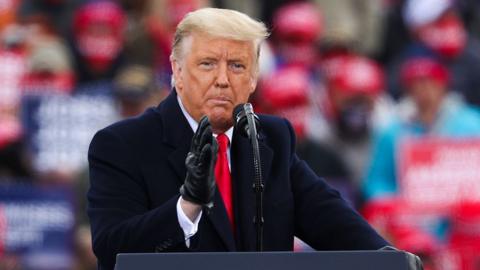 Donald Trump gesturest with a gloved hand as he addresses his supporters during a rally in Pennsylvania, United States on October 31, 2020